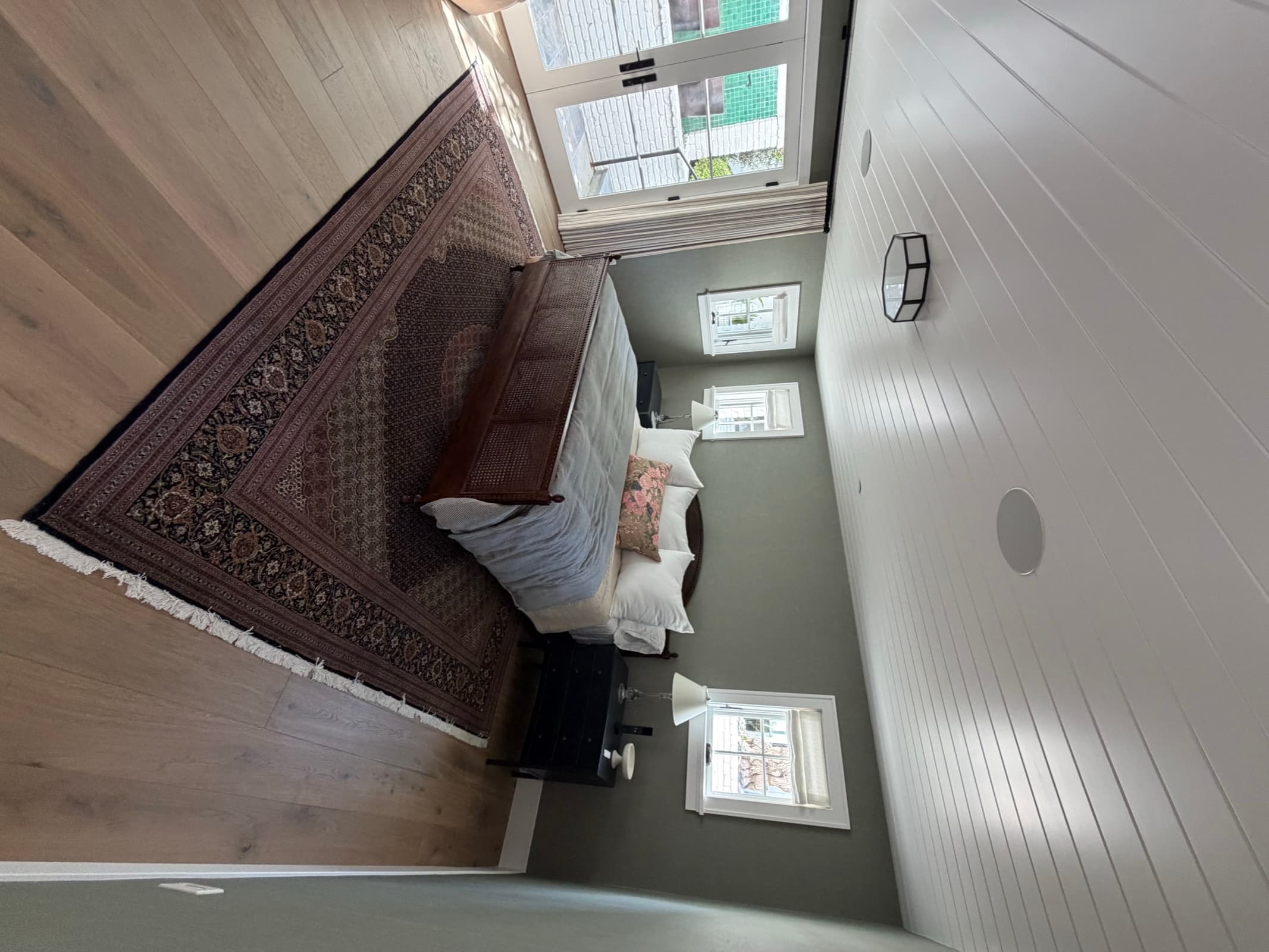 After: wide-plank oak flooring, new windows and trim, and French doors to the patio