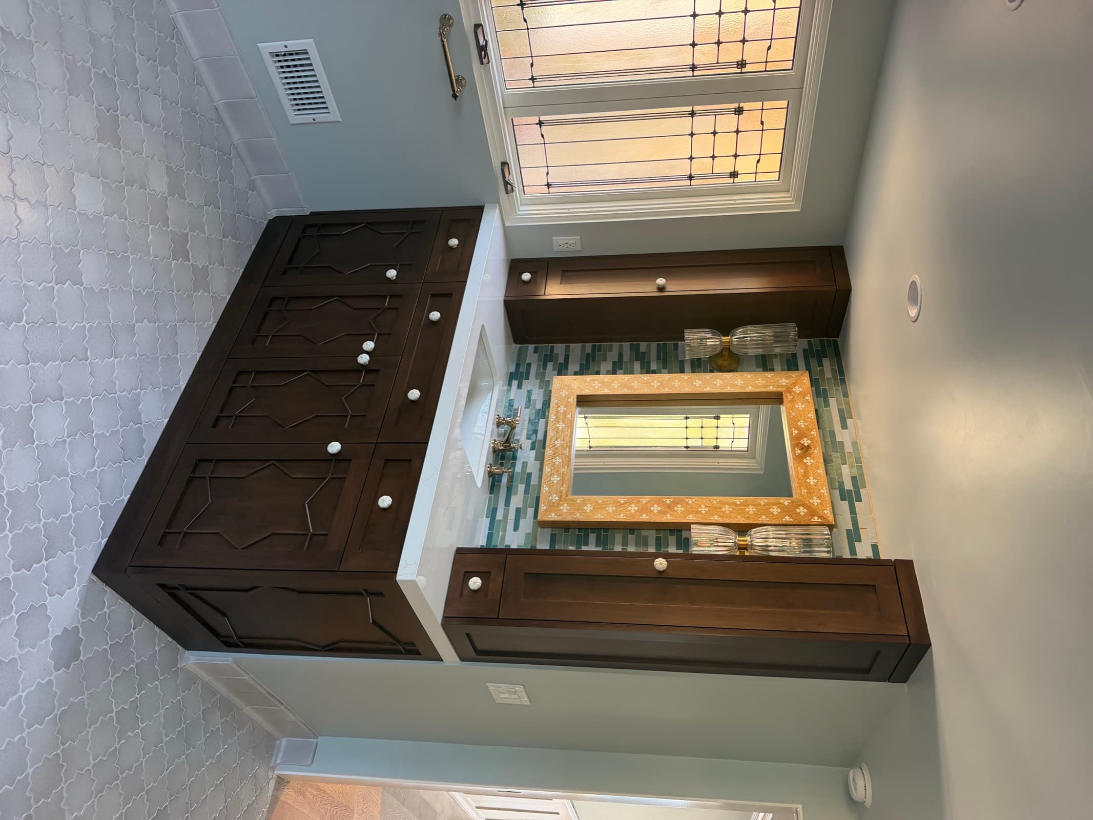 Carved fretwork vanity with inlay-framed mirror and blue-green tile wall