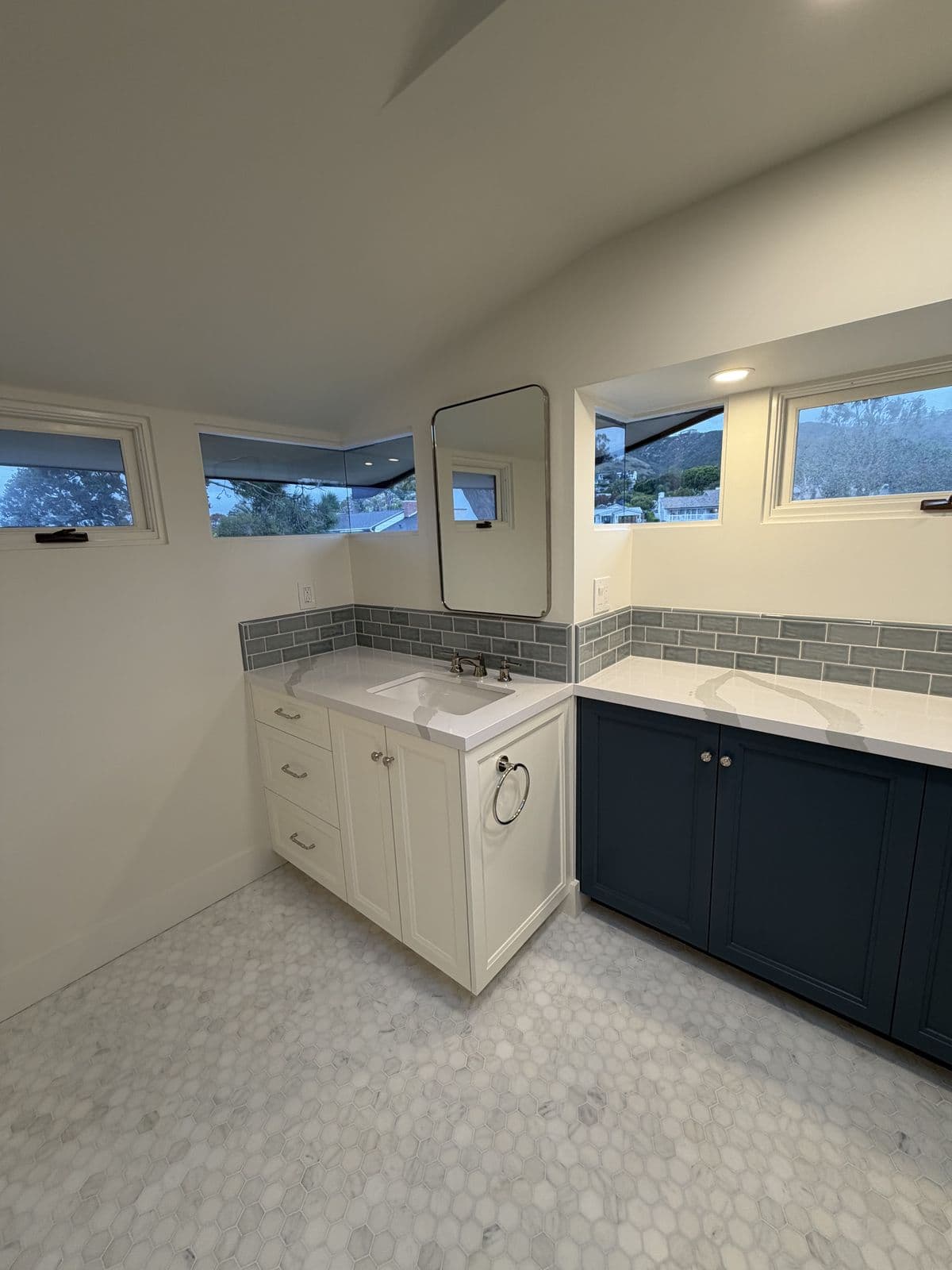 Navy and white vanities with hexagon marble-look floor tile